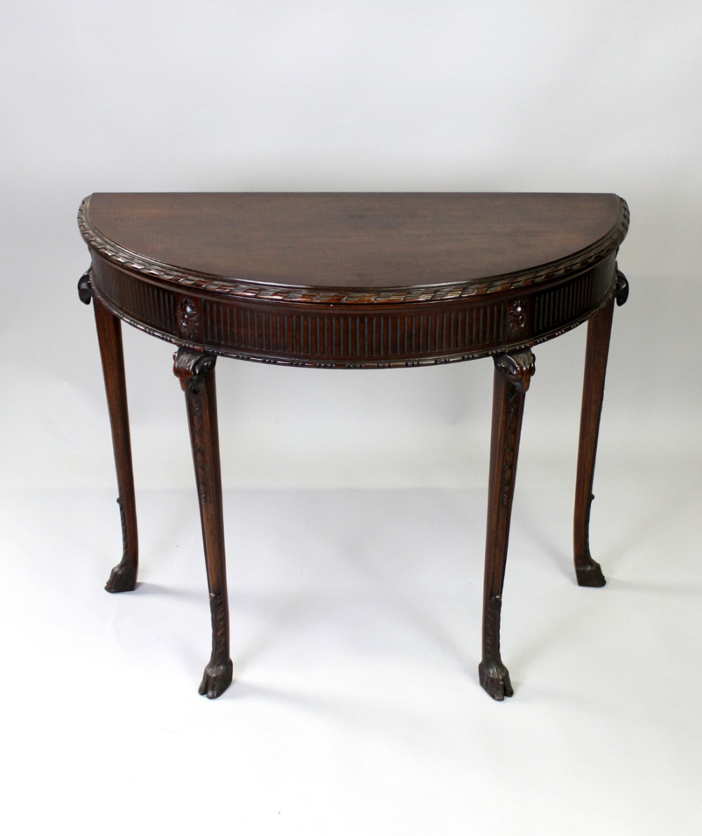 A CARVED MAHOGANY DEMI LUNE CARD TABLE