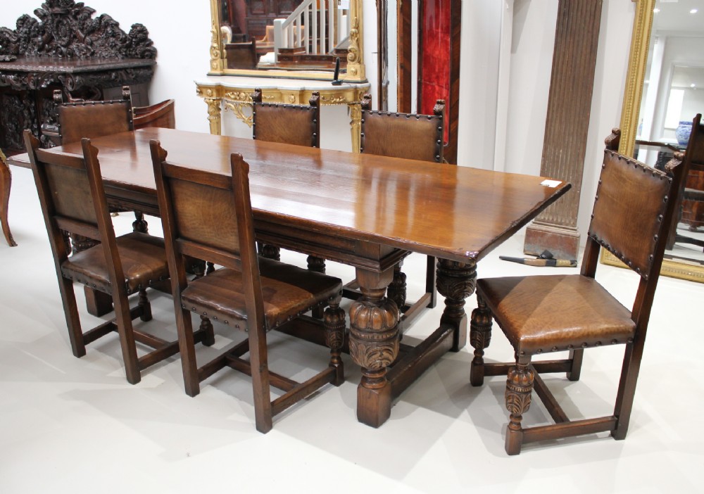 A VERY BEAUTIFUL CARVED OAK REFECTORY TABLE AND SIX LEATHER CHAIRS