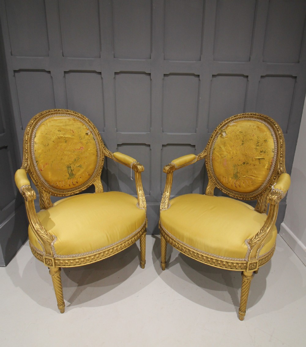 A PAIR OF CARVED GILTWOOD OPEN ARMCHAIRS 