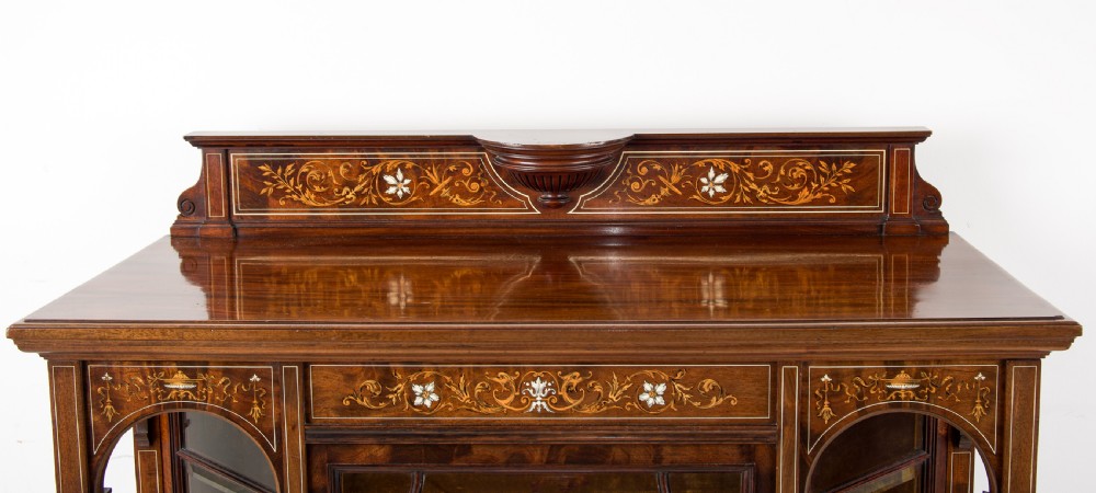 A Victorian dark brown timber display cabinet featuring intricate floral marquetry inlay, glazed central doors with geometric glazing bars, and an open lower shelf. View IV