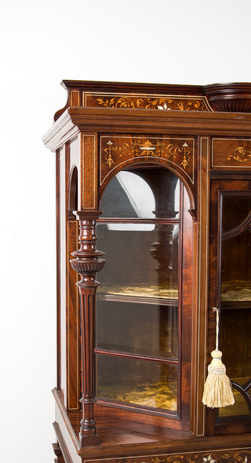 A Victorian dark brown timber display cabinet featuring intricate floral marquetry inlay, glazed central doors with geometric glazing bars, and an open lower shelf. View VI