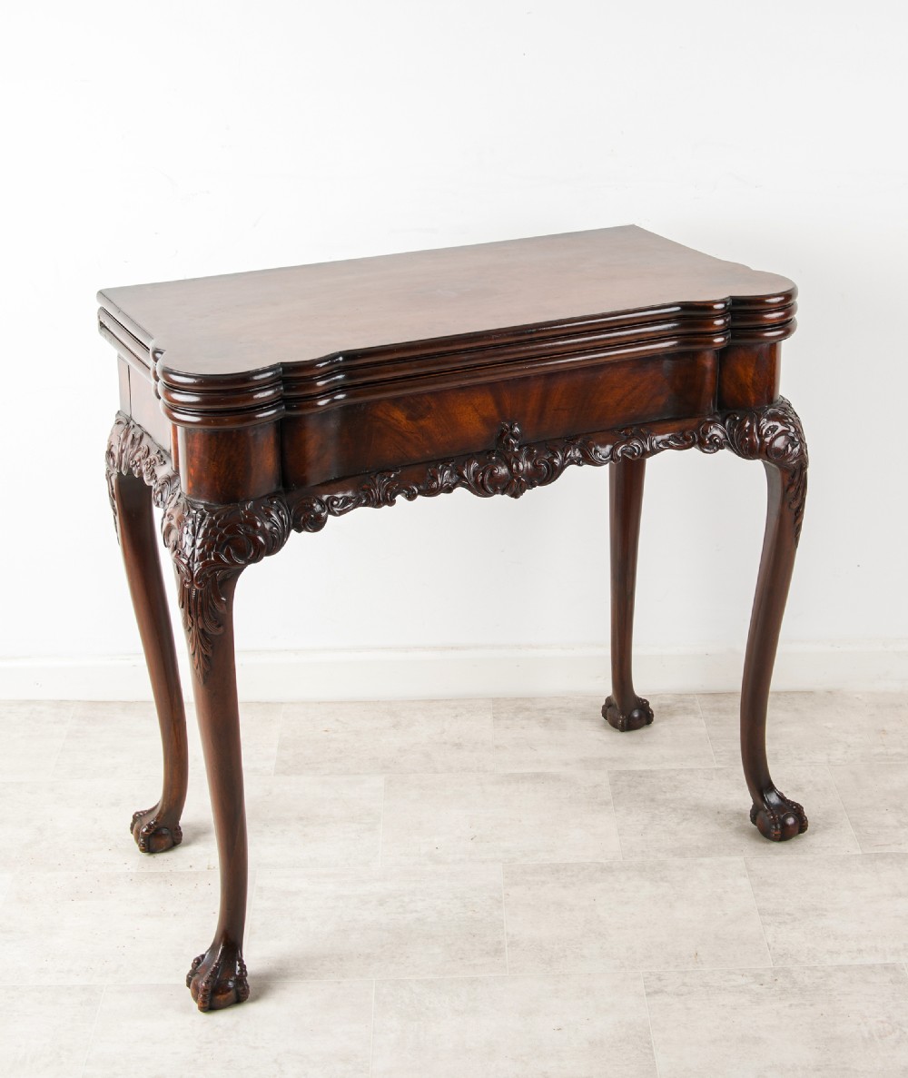 A dark mahogany George II style dual-action tea and card table with carved cabriole legs and ball and claw feet. View III