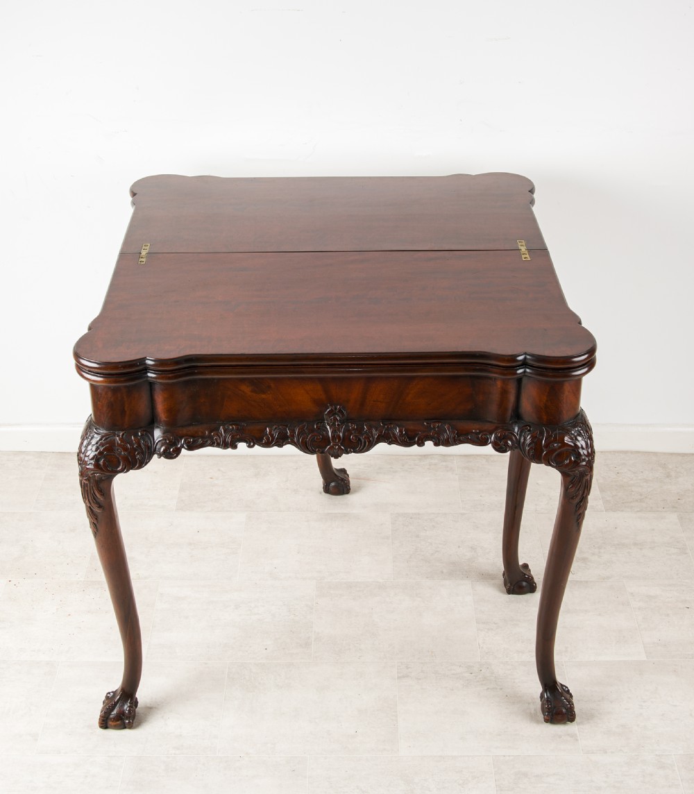 A dark mahogany George II style dual-action tea and card table with carved cabriole legs and ball and claw feet. View IV