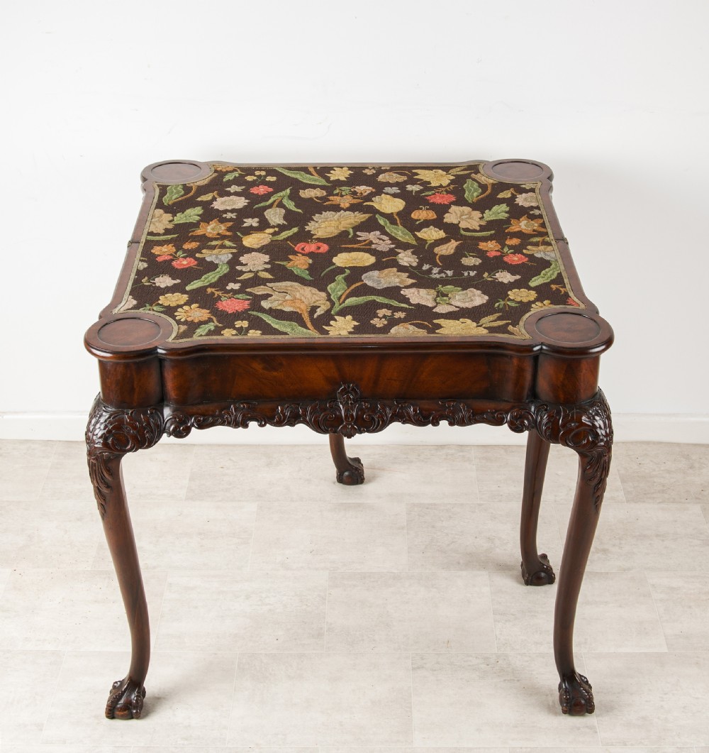 A dark mahogany George II style dual-action tea and card table with carved cabriole legs and ball and claw feet. View VI