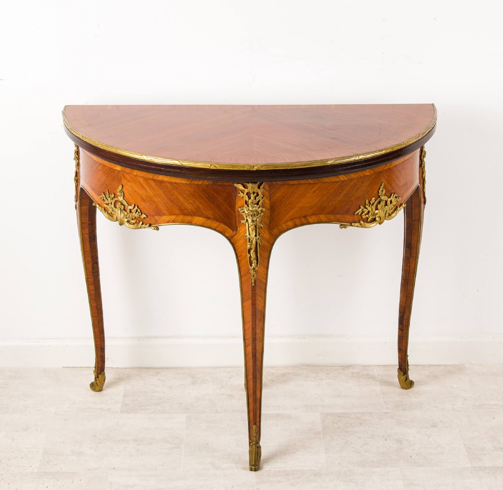 A French Louis XV style demi-lune kingwood games table with gilt-bronze mounts and slender cabriole legs. View II