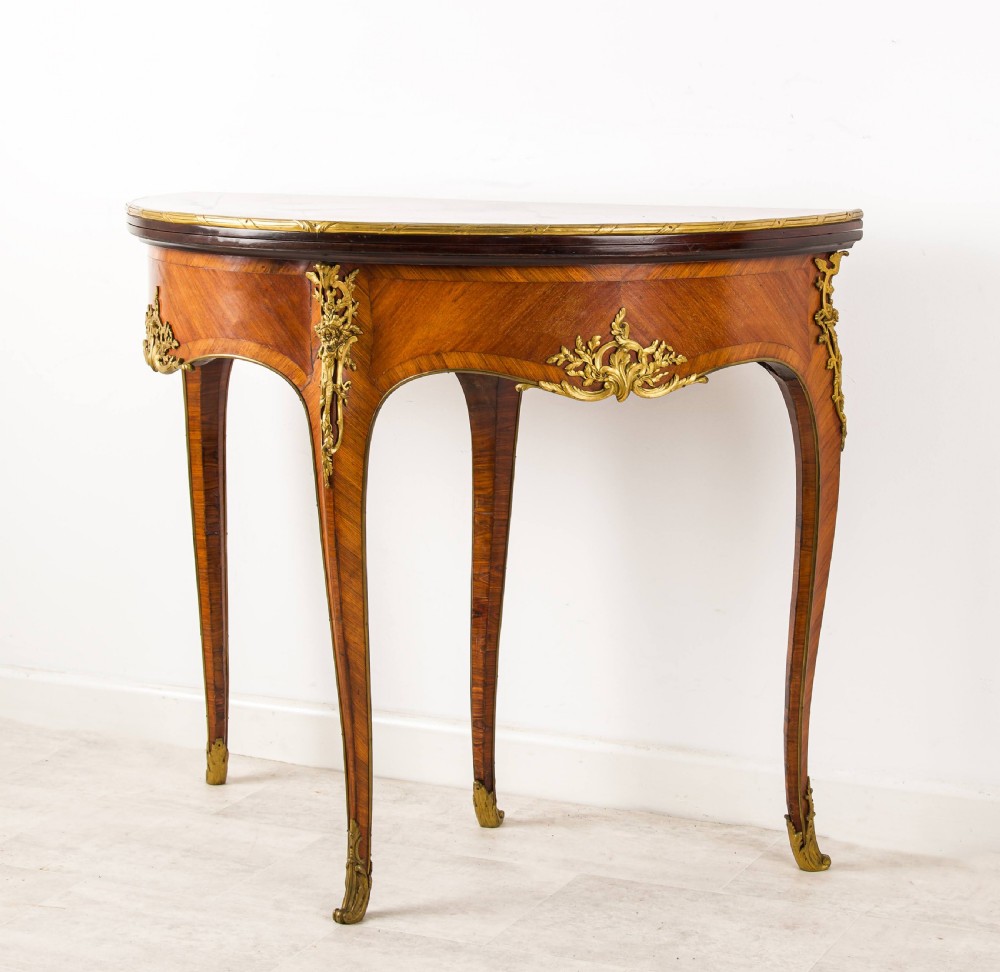 A French Louis XV style demi-lune kingwood games table with gilt-bronze mounts and slender cabriole legs. View VI