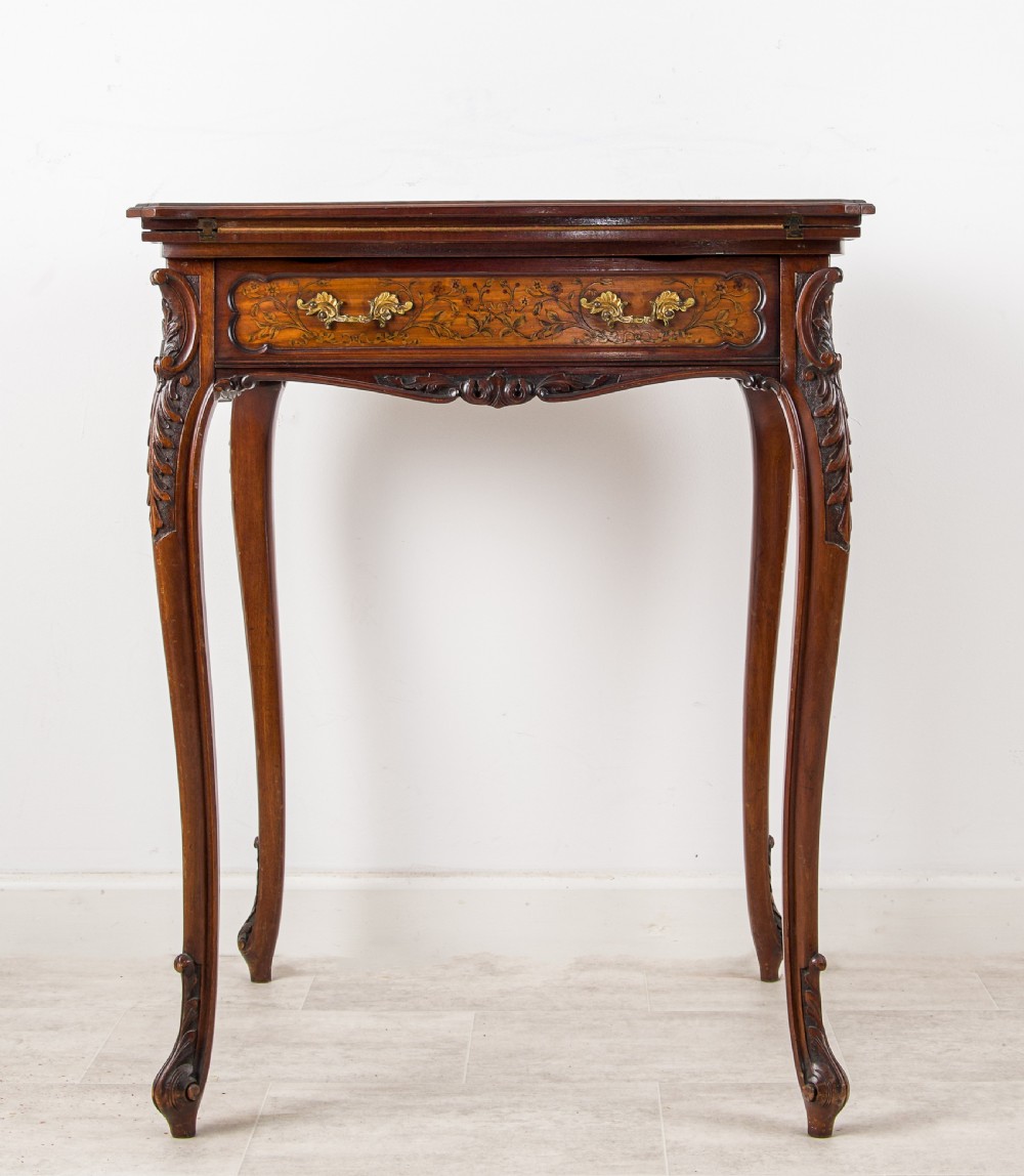 A 19th-century mahogany envelope games table with floral marquetry inlay, cabriole legs, and a single drawer with brass pulls. View II