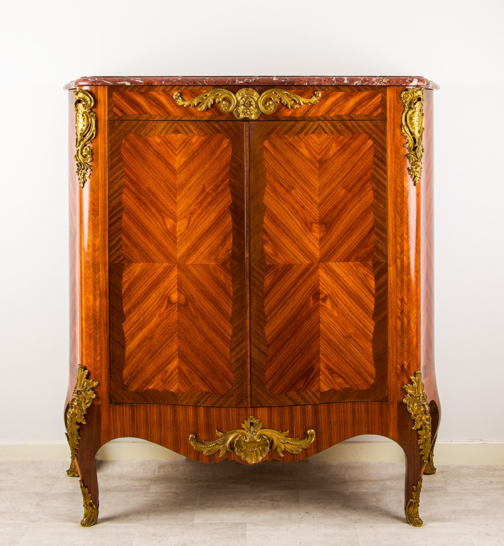 A 19th-century French kingwood side cabinet featuring geometric parquetry doors, gilt bronze mounts, and a marble top.