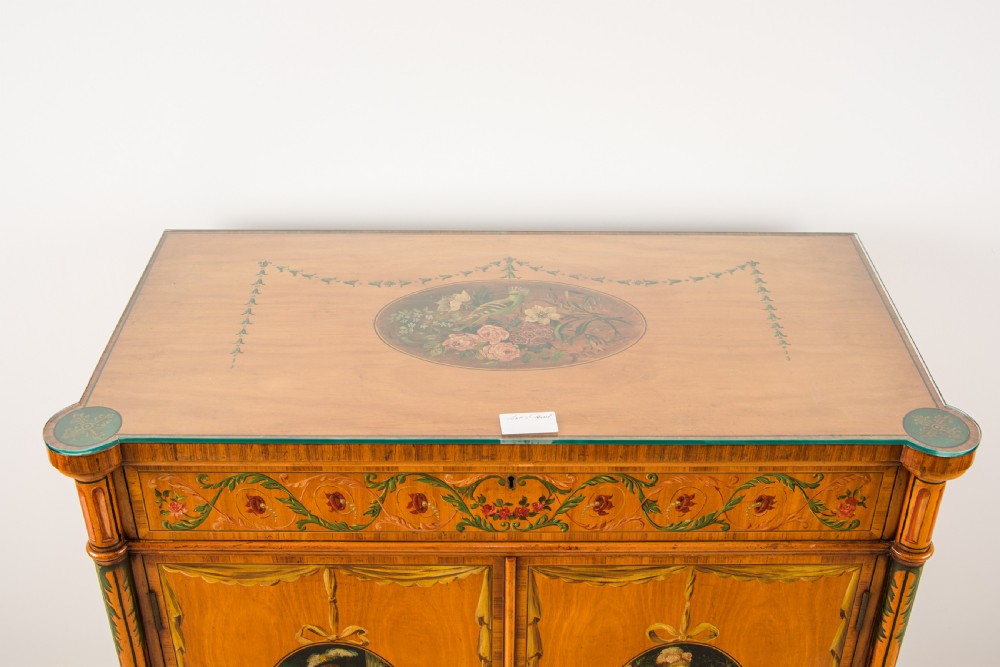 An Edwardian satinwood side cabinet featuring hand-painted floral garlands on the frieze and oval portrait medallions on two front doors, supported by slender turned legs. View III