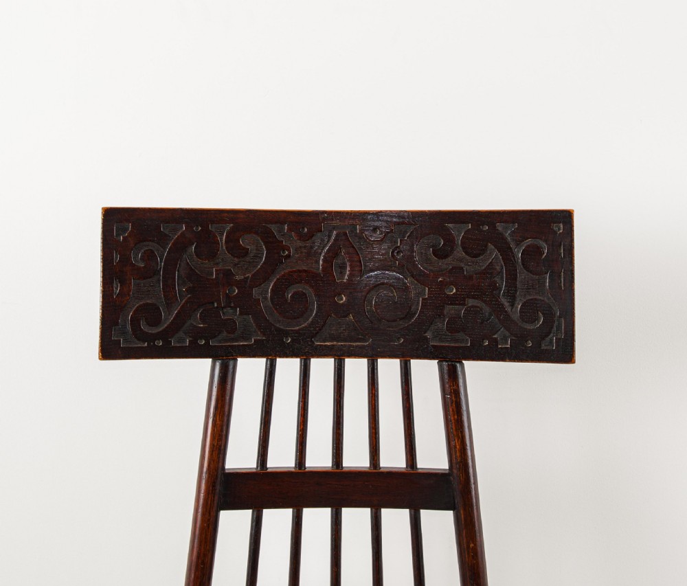 An antique dark oak Arts and Crafts side chair featuring a carved high backrest, spindle grid detailing, twisted front legs, and a needlepoint floral seat. View III