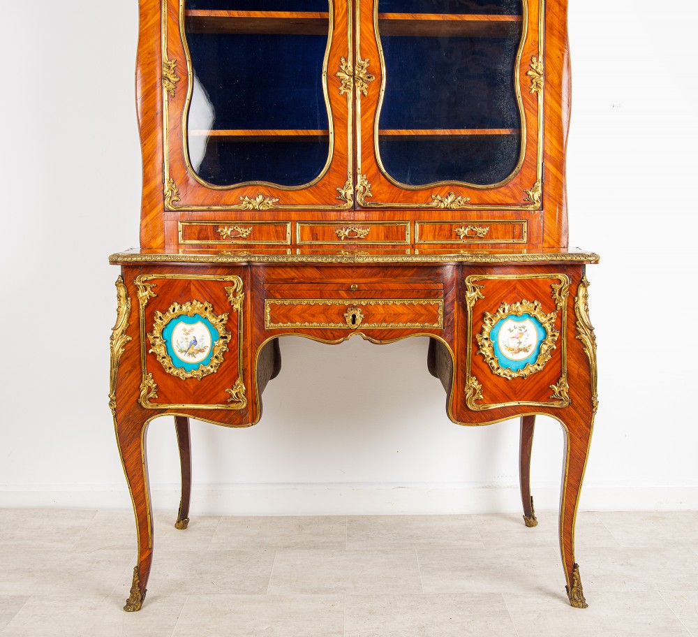 An antique French kingwood Bonheur du Jour cabinet featuring glazed upper doors, ornate ormolu mounts, Sevres style porcelain plaques, and cabriole legs. View II