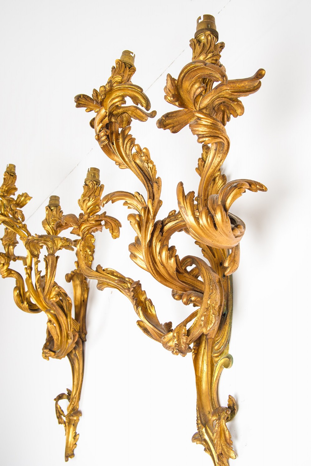 A pair of gilt bronze French ormolu three-branch wall lights decorated with sweeping Rococo acanthus leaf scrollwork. View XI