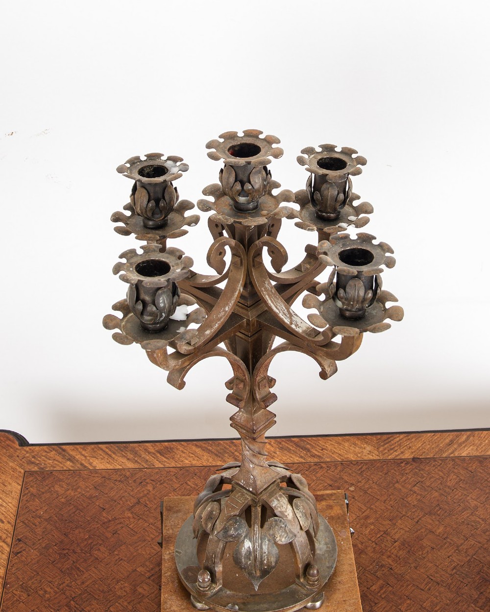 A pair of five-branch Gothic Revival metal candelabra featuring foliate cups, twisted columns, and wooden bases with iron strapwork. View VII