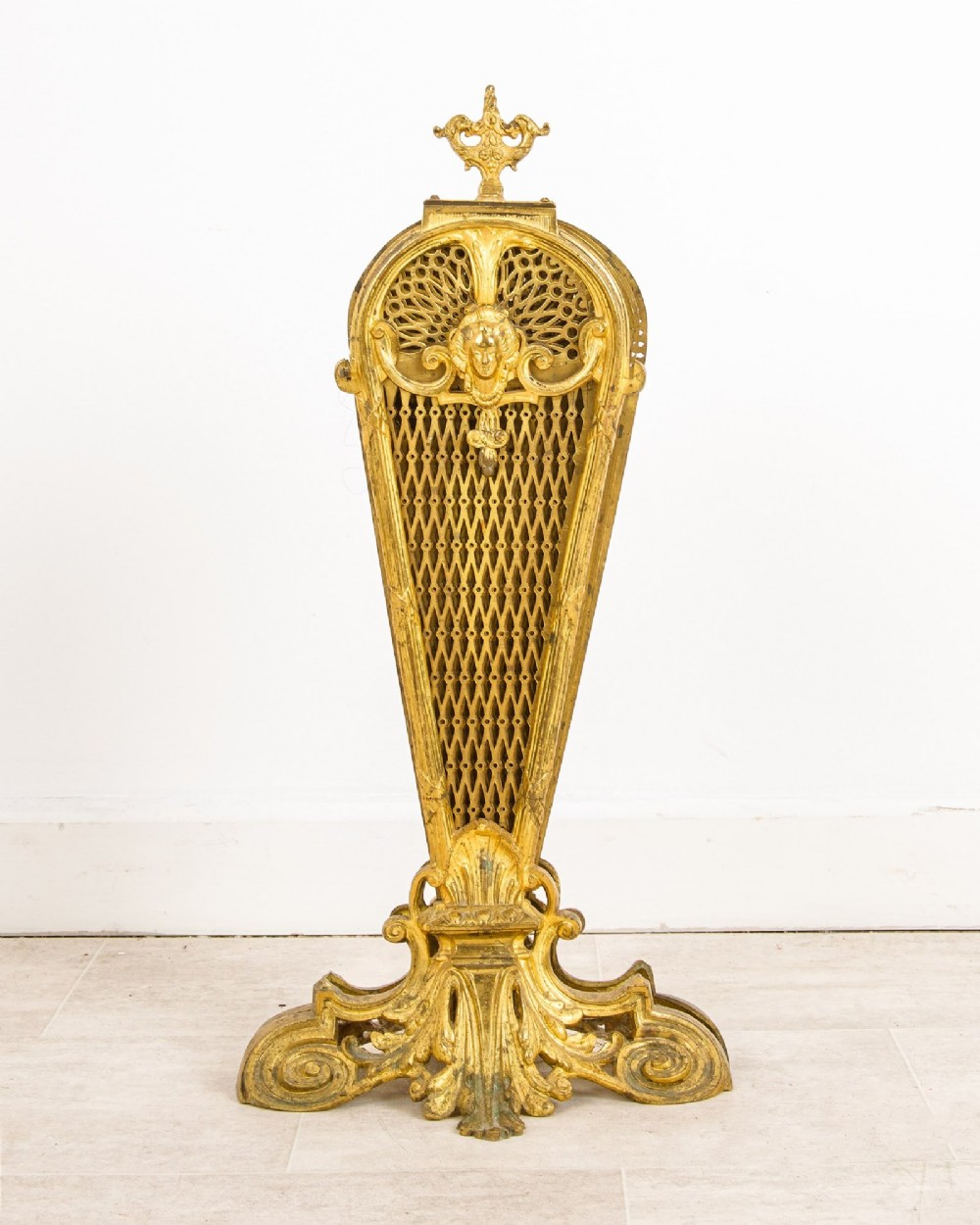 A French gilt brass peacock fan fire screen featuring pierced filigree blades unfolding from a central Rococo scroll base. View II