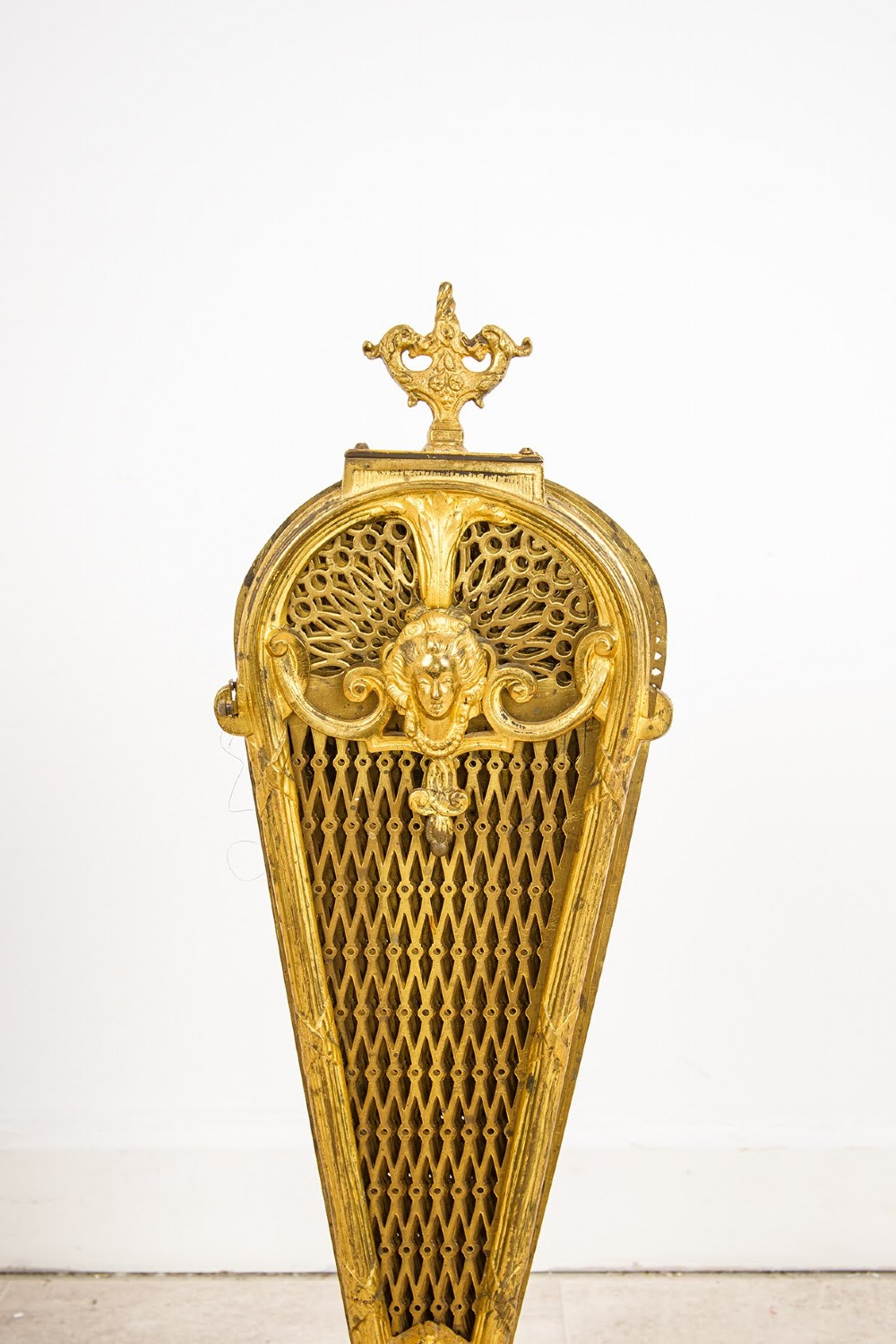 A French gilt brass peacock fan fire screen featuring pierced filigree blades unfolding from a central Rococo scroll base. View IV