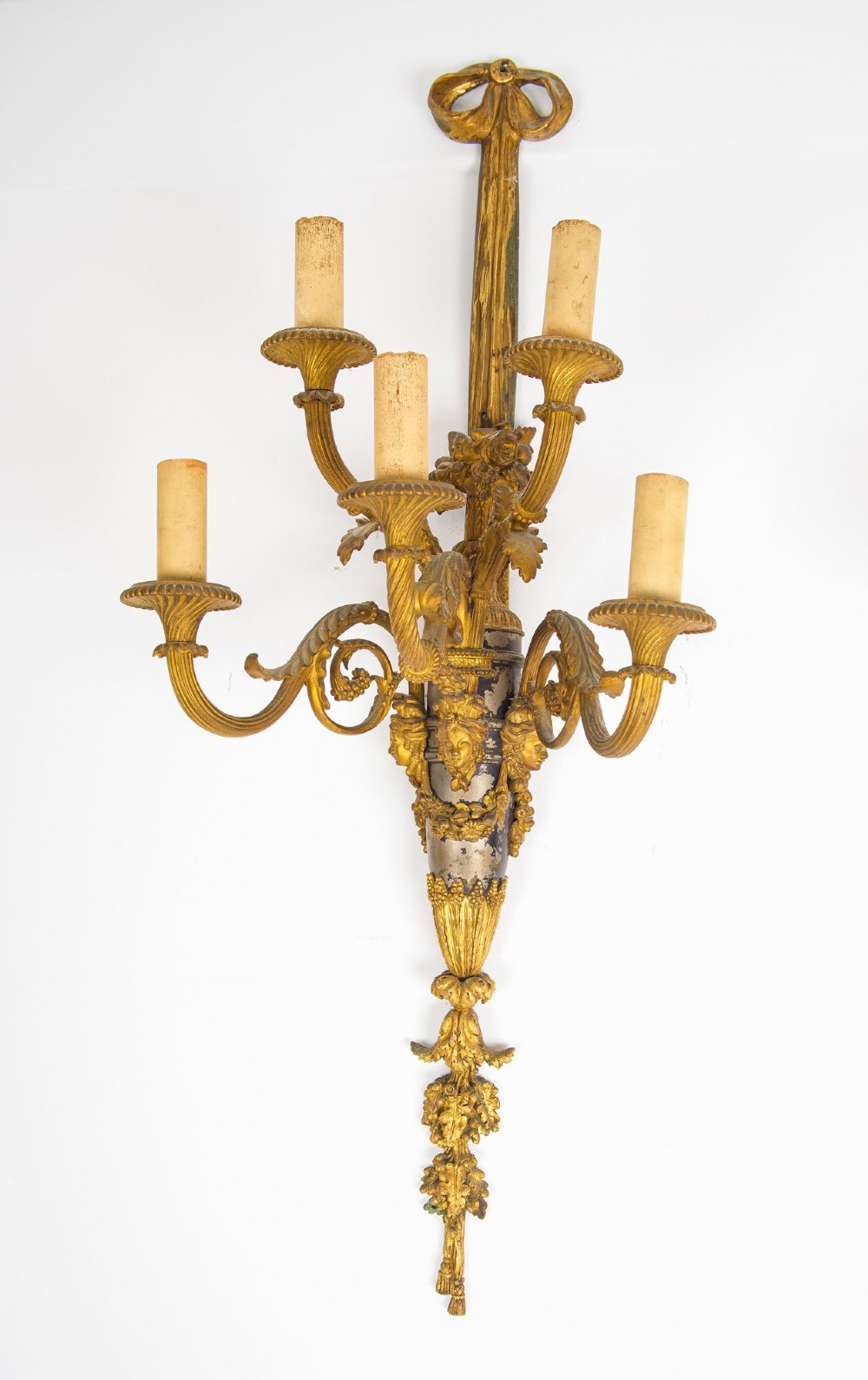 A pair of French Louis XVI style gilt-bronze five-light wall sconces featuring ribbon bow tops, leaf motifs, and classical mask details. View III