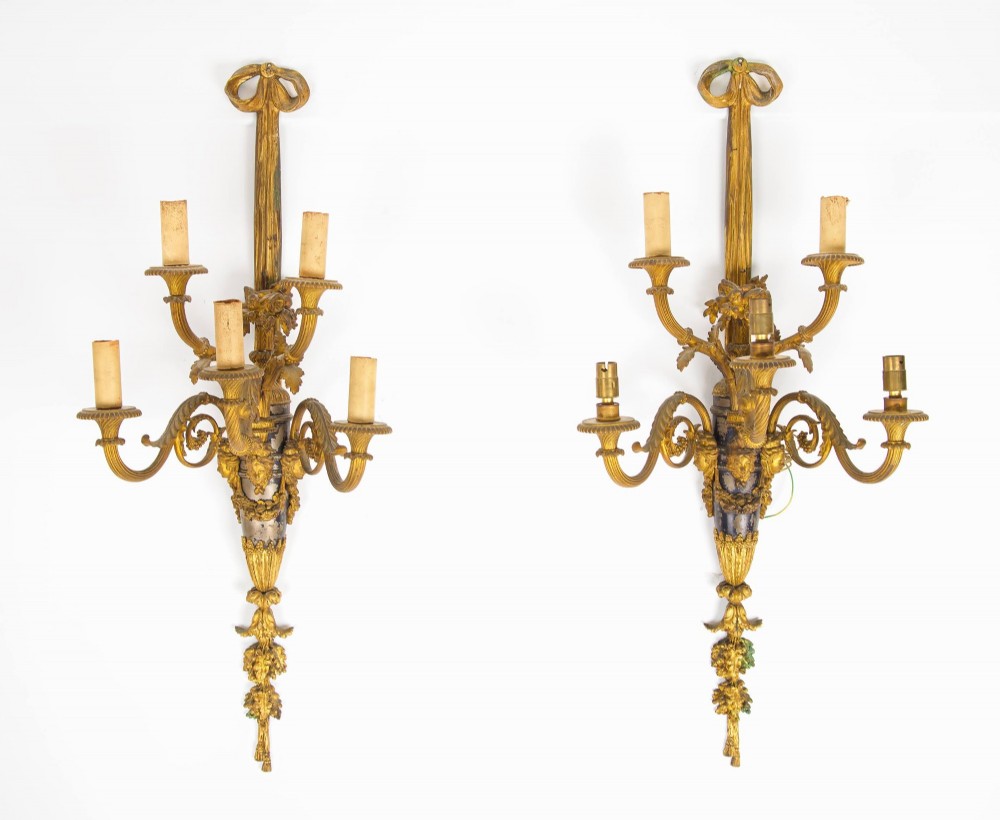 A pair of French Louis XVI style gilt-bronze five-light wall sconces featuring ribbon bow tops, leaf motifs, and classical mask details. View IV
