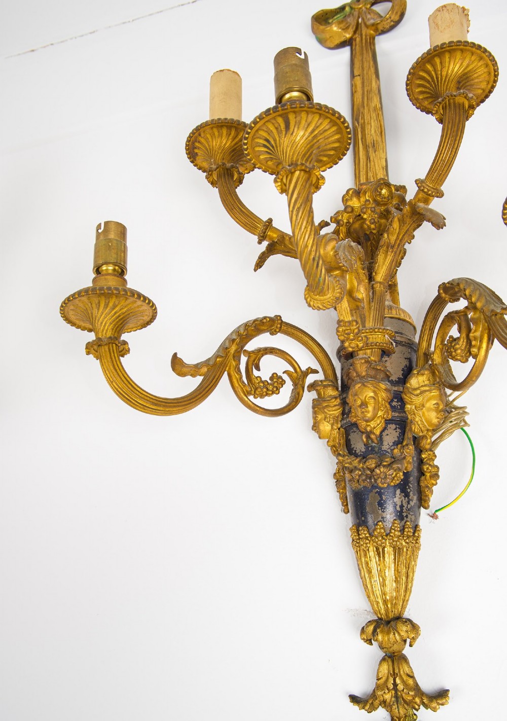 A pair of French Louis XVI style gilt-bronze five-light wall sconces featuring ribbon bow tops, leaf motifs, and classical mask details. View VII