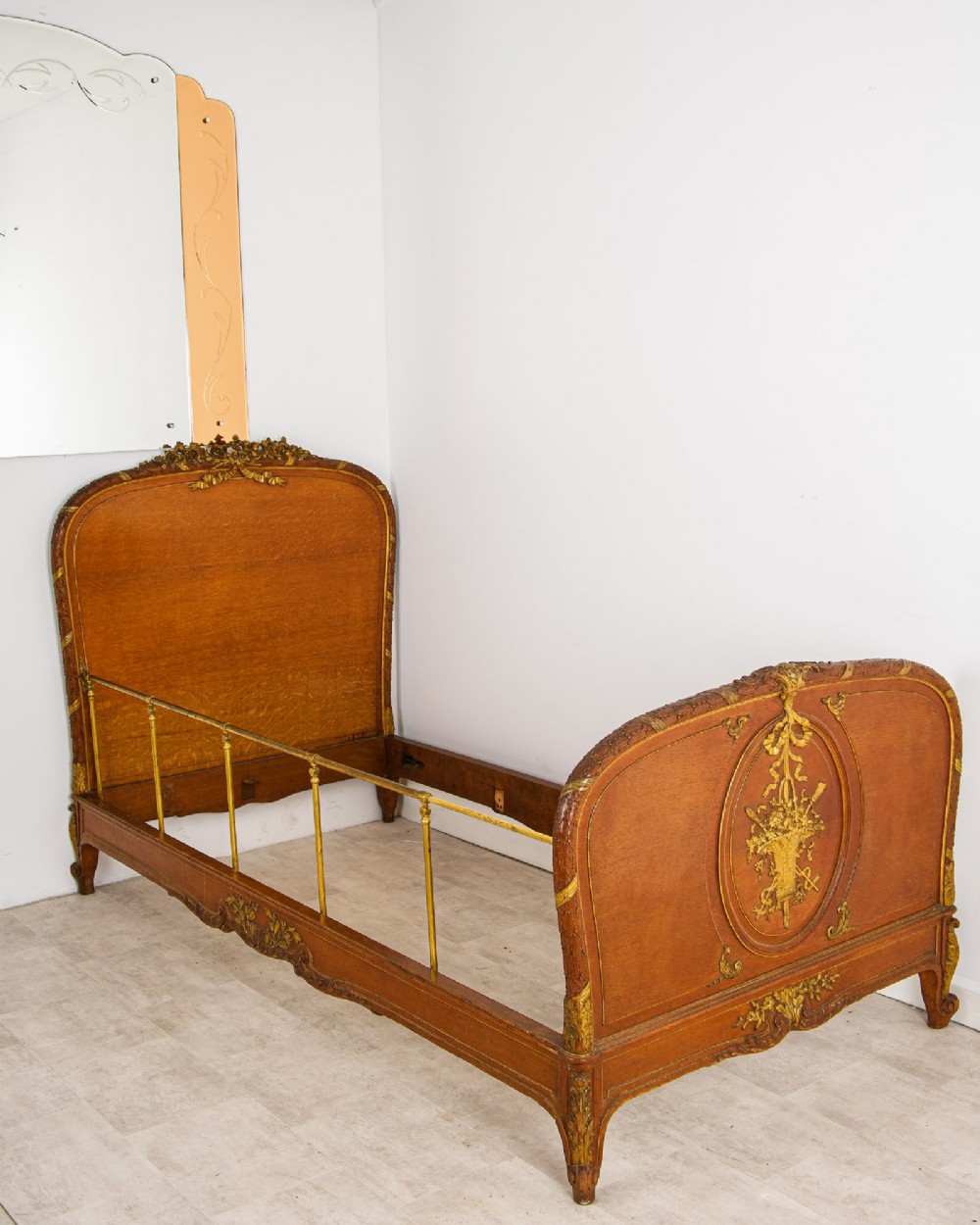 An antique French Louis XV style daybed featuring polished walnut panels, giltwood rococo carvings, and brass side rails. View IV