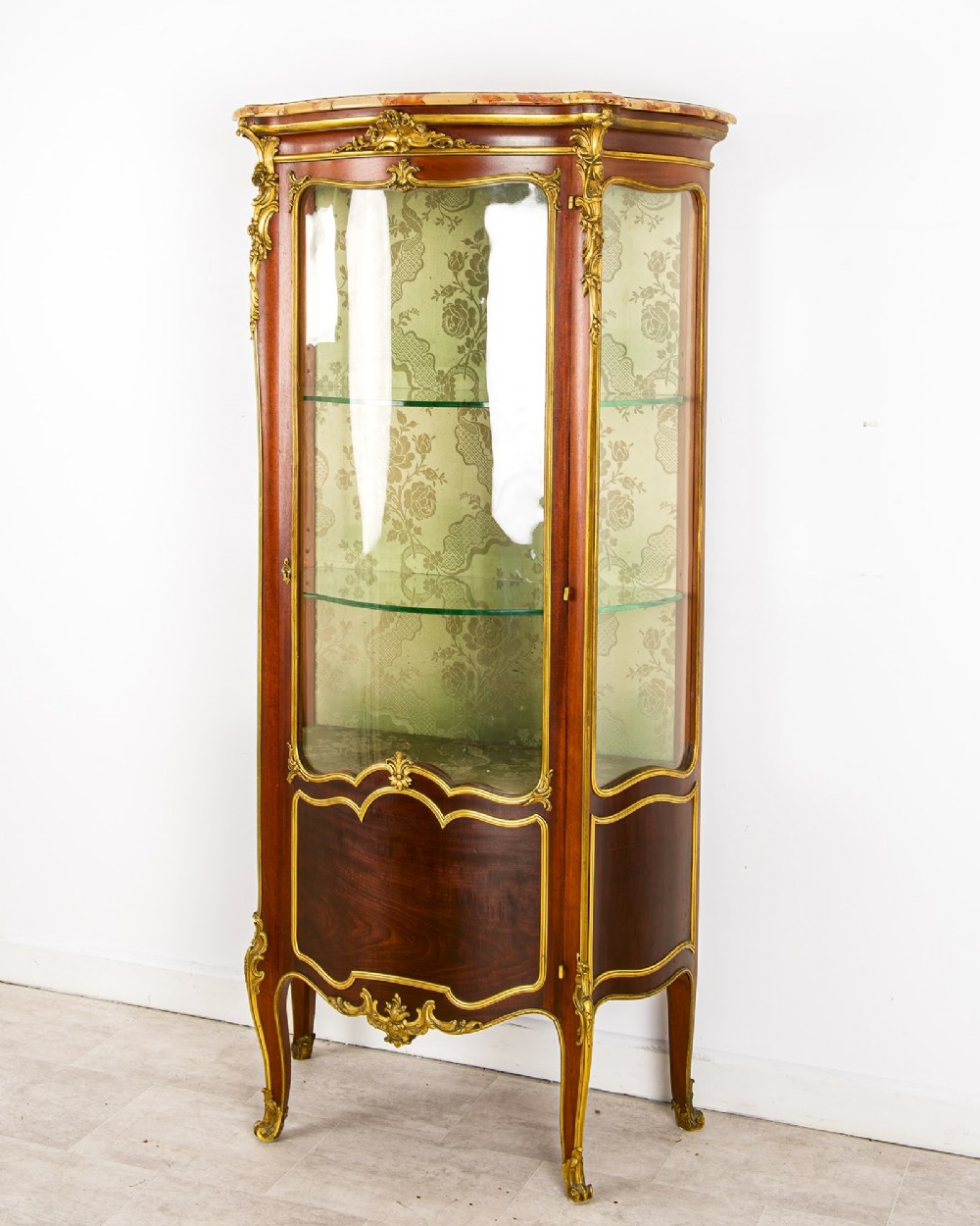 An antique French Louis XV style vitrine cabinet featuring a marble top, glass panels, a fabric-lined interior with glass shelves, and gilt bronze mounts throughout. View III