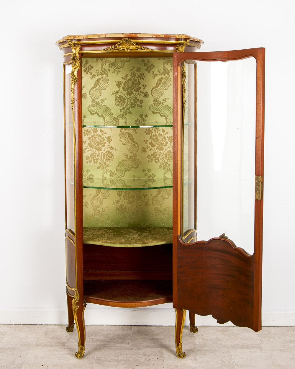 An antique French Louis XV style vitrine cabinet featuring a marble top, glass panels, a fabric-lined interior with glass shelves, and gilt bronze mounts throughout. View VI