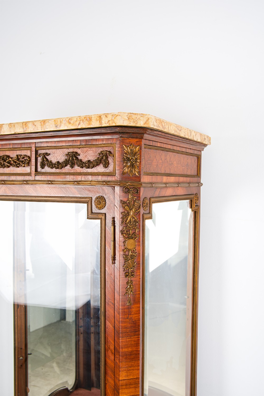An antique French kingwood vitrine cabinet featuring ornate ormolu mounts, a glazed door with a mirrored interior back, and a contoured marble top resting on slender cabriole legs. View V