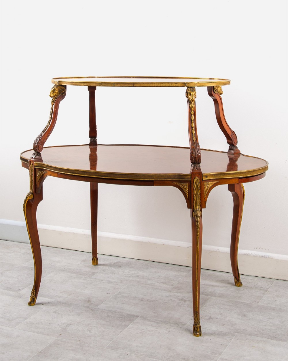 A two-tier French mahogany etagere centre table featuring oval surfaces, slender cabriole legs, and ornate gilded ormolu mounts. View II