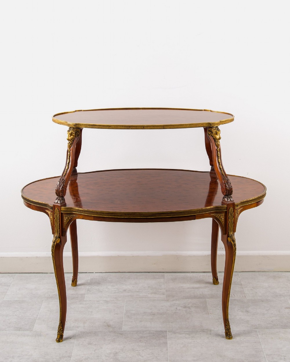A two-tier French mahogany etagere centre table featuring oval surfaces, slender cabriole legs, and ornate gilded ormolu mounts. View III