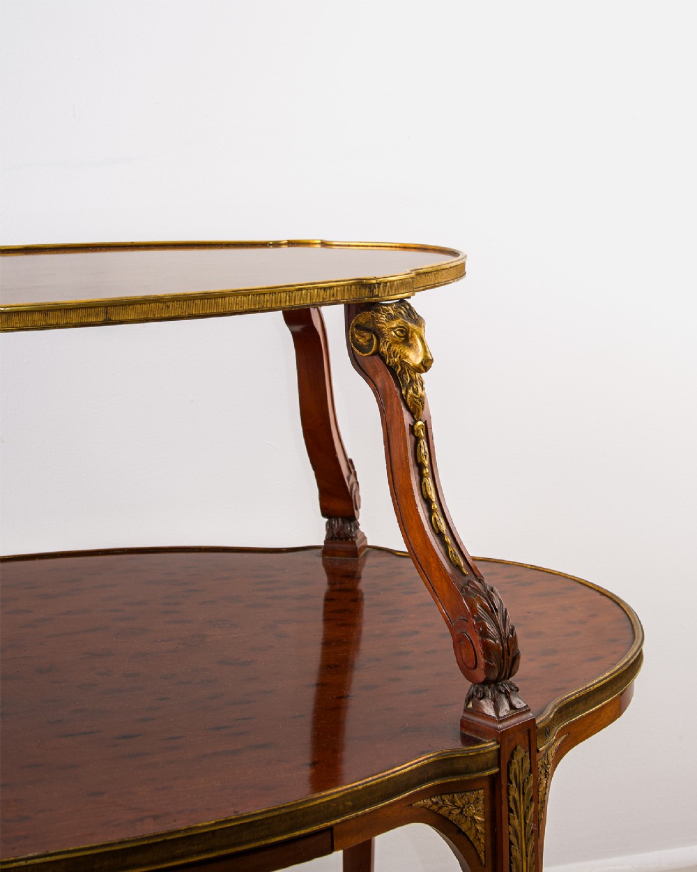 A two-tier French mahogany etagere centre table featuring oval surfaces, slender cabriole legs, and ornate gilded ormolu mounts. View IV