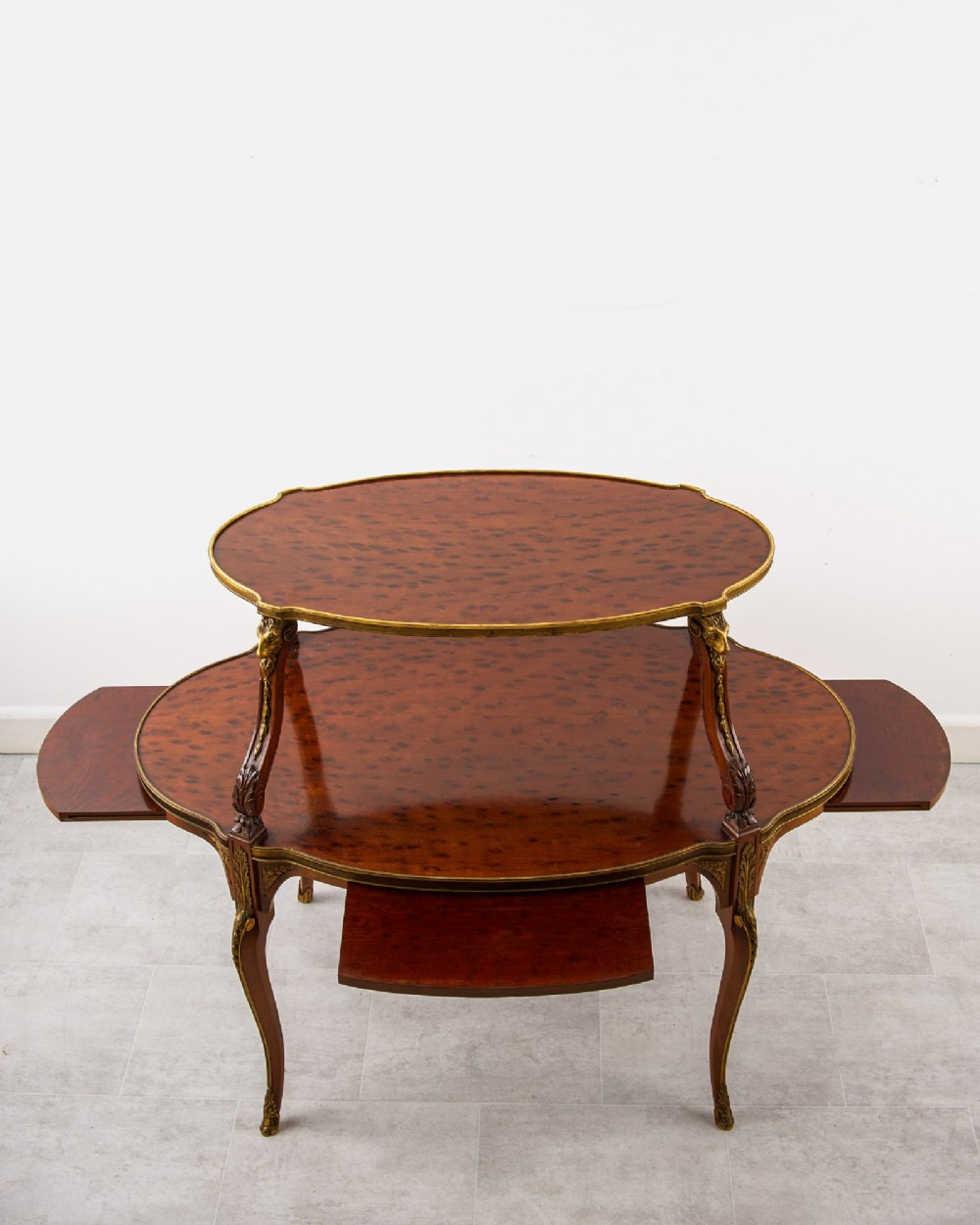 A two-tier French mahogany etagere centre table featuring oval surfaces, slender cabriole legs, and ornate gilded ormolu mounts. View VI