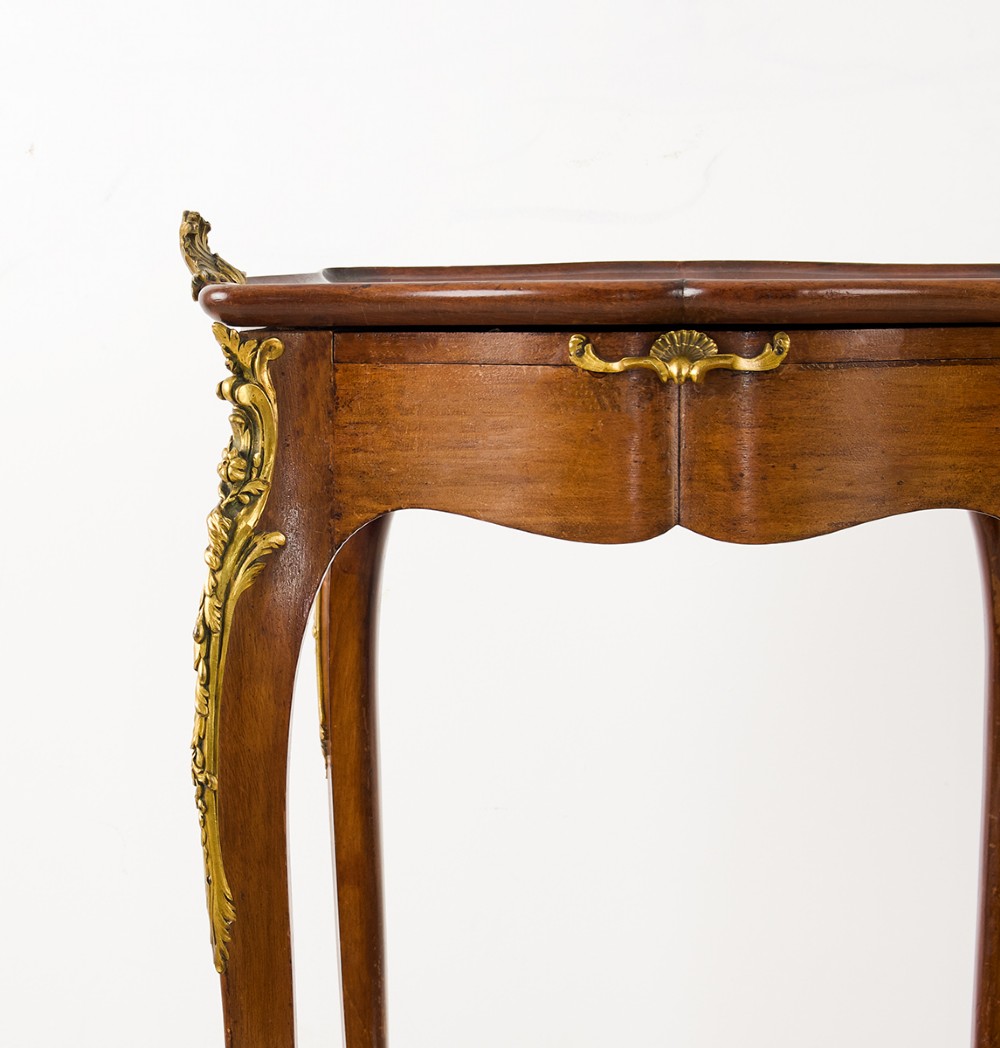 A French Louis XV style mahogany side table featuring gilt bronze mounts, cabriole legs, a serpentine upper top, and a lower tier shelf. View III
