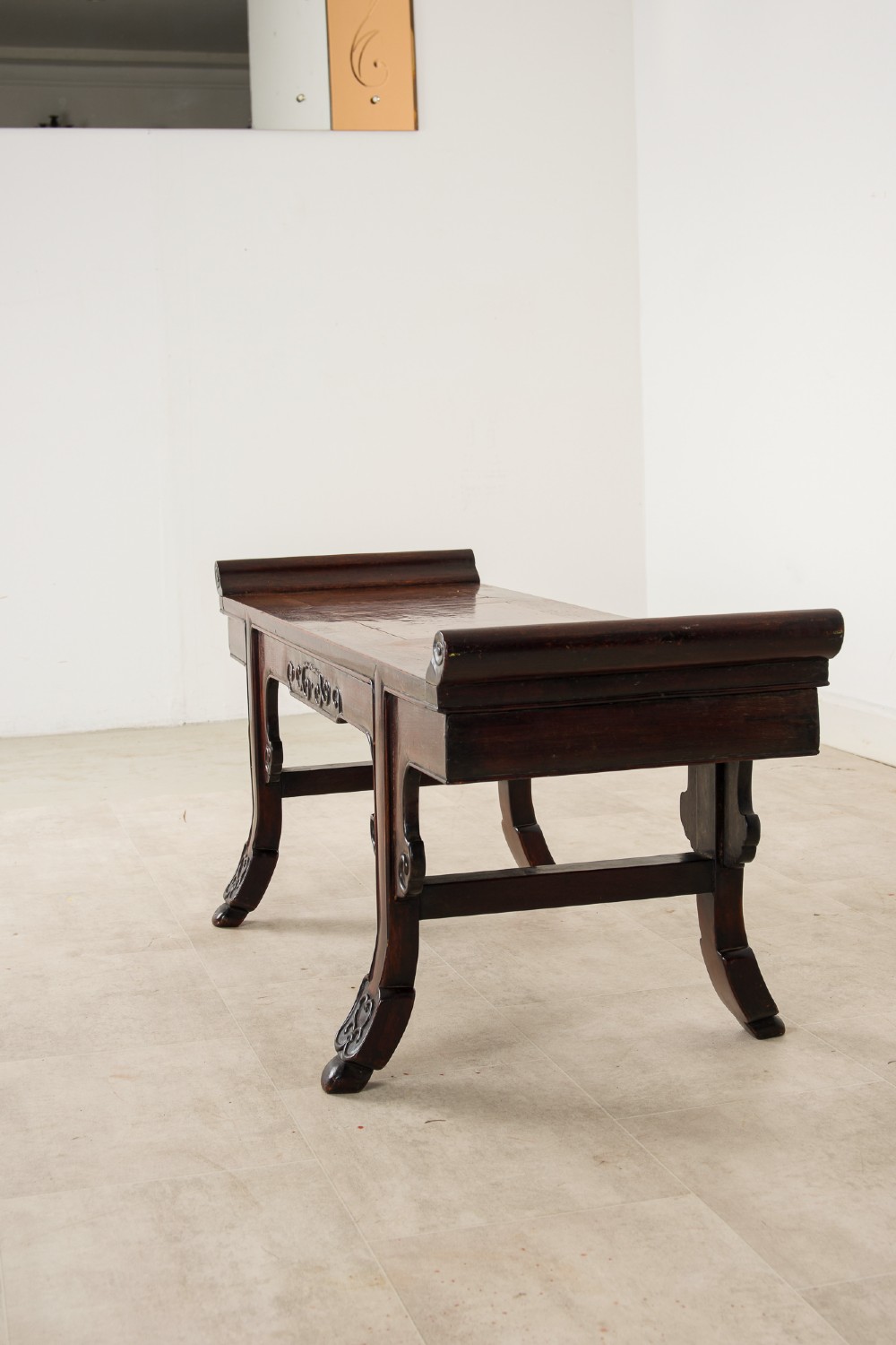 A nineteenth-century Chinese dark hardwood altar bench featuring raised scroll ends, a carved apron, and spandrels. View IV