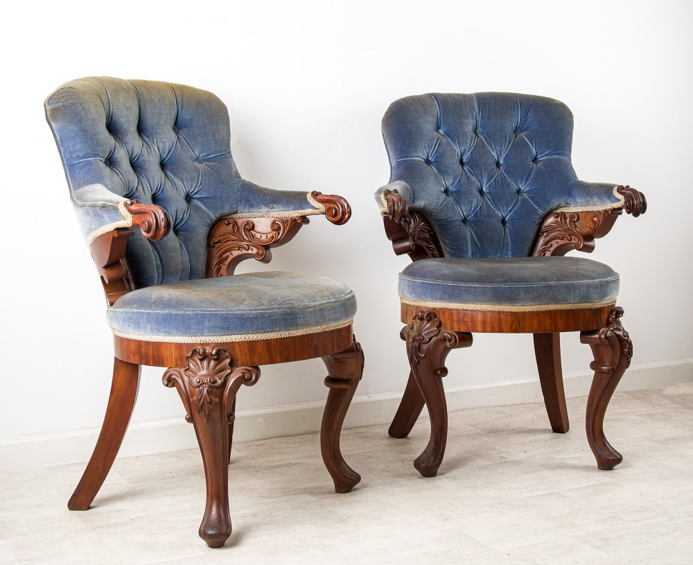 A pair of Victorian carved mahogany armchairs with button-backed blue velvet upholstery and detailed carved legs. View II