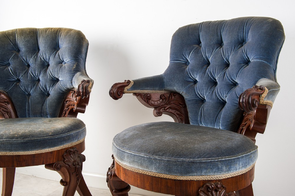 A pair of Victorian carved mahogany armchairs with button-backed blue velvet upholstery and detailed carved legs. View IV