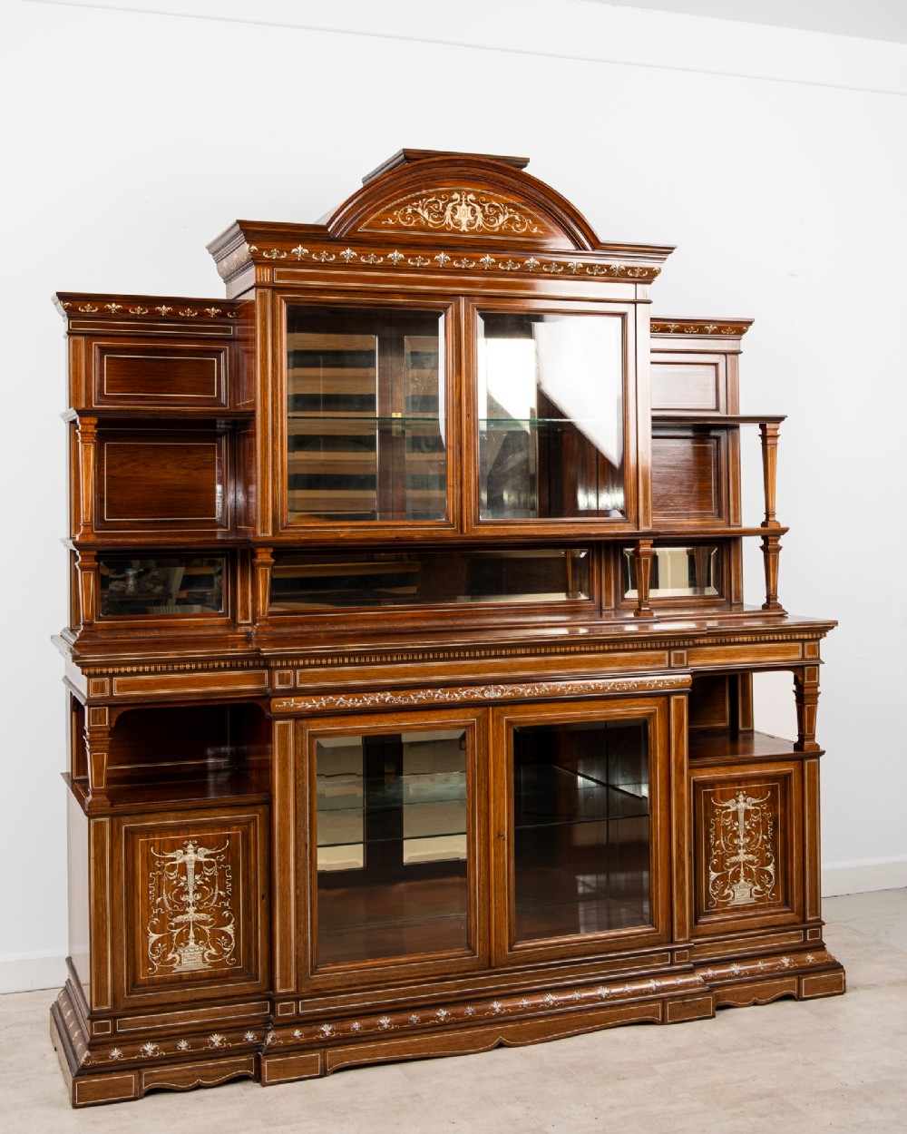 A monumental Victorian rosewood display cabinet featuring marquetry inlay, glazed doors, mirrored panels, and multi-tiered shelving. View III