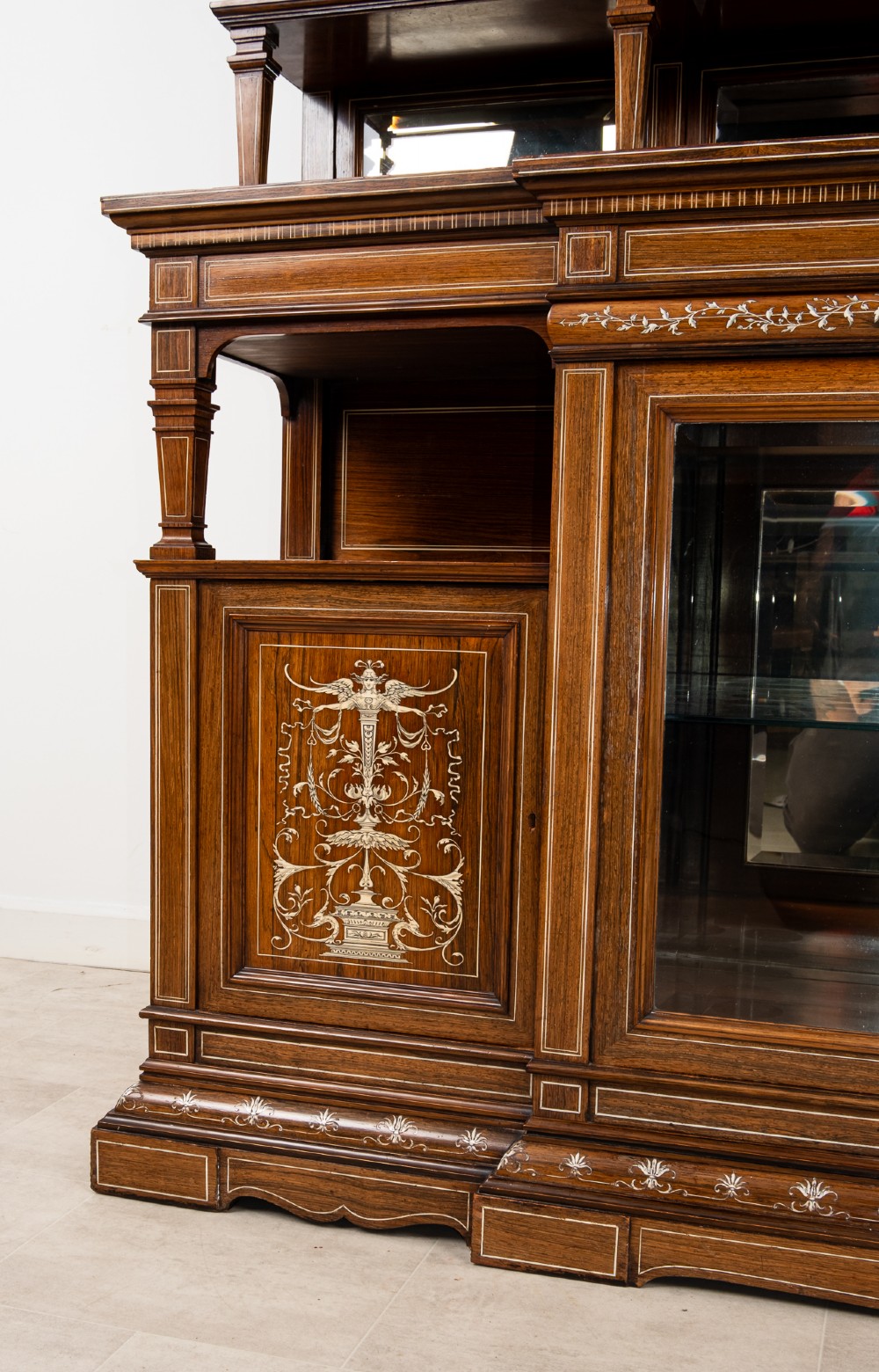 A monumental Victorian rosewood display cabinet featuring marquetry inlay, glazed doors, mirrored panels, and multi-tiered shelving. View VIII