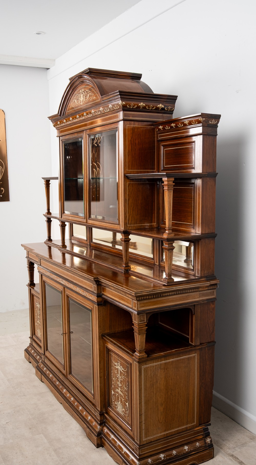 A monumental Victorian rosewood display cabinet featuring marquetry inlay, glazed doors, mirrored panels, and multi-tiered shelving. View IX