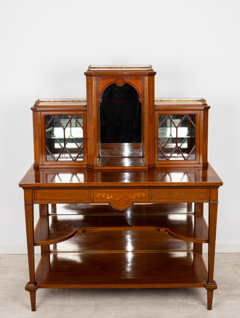 An Edwardian mahogany bonheur du jour writing desk featuring floral marquetry inlay, central mirrored recess, glazed side cabinets, and open lower shelves. View III