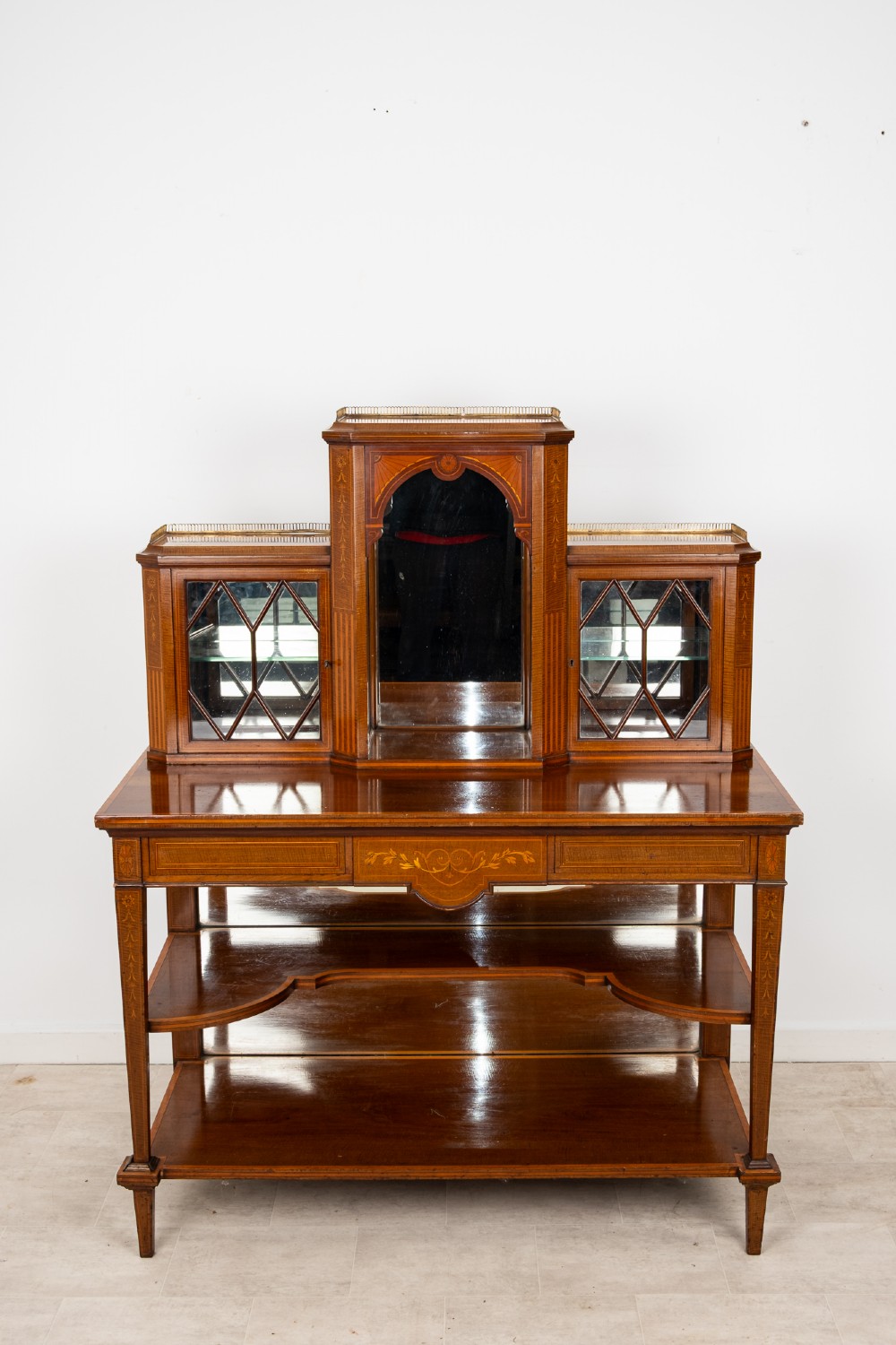 An Edwardian mahogany bonheur du jour writing desk featuring floral marquetry inlay, central mirrored recess, glazed side cabinets, and open lower shelves. View IV