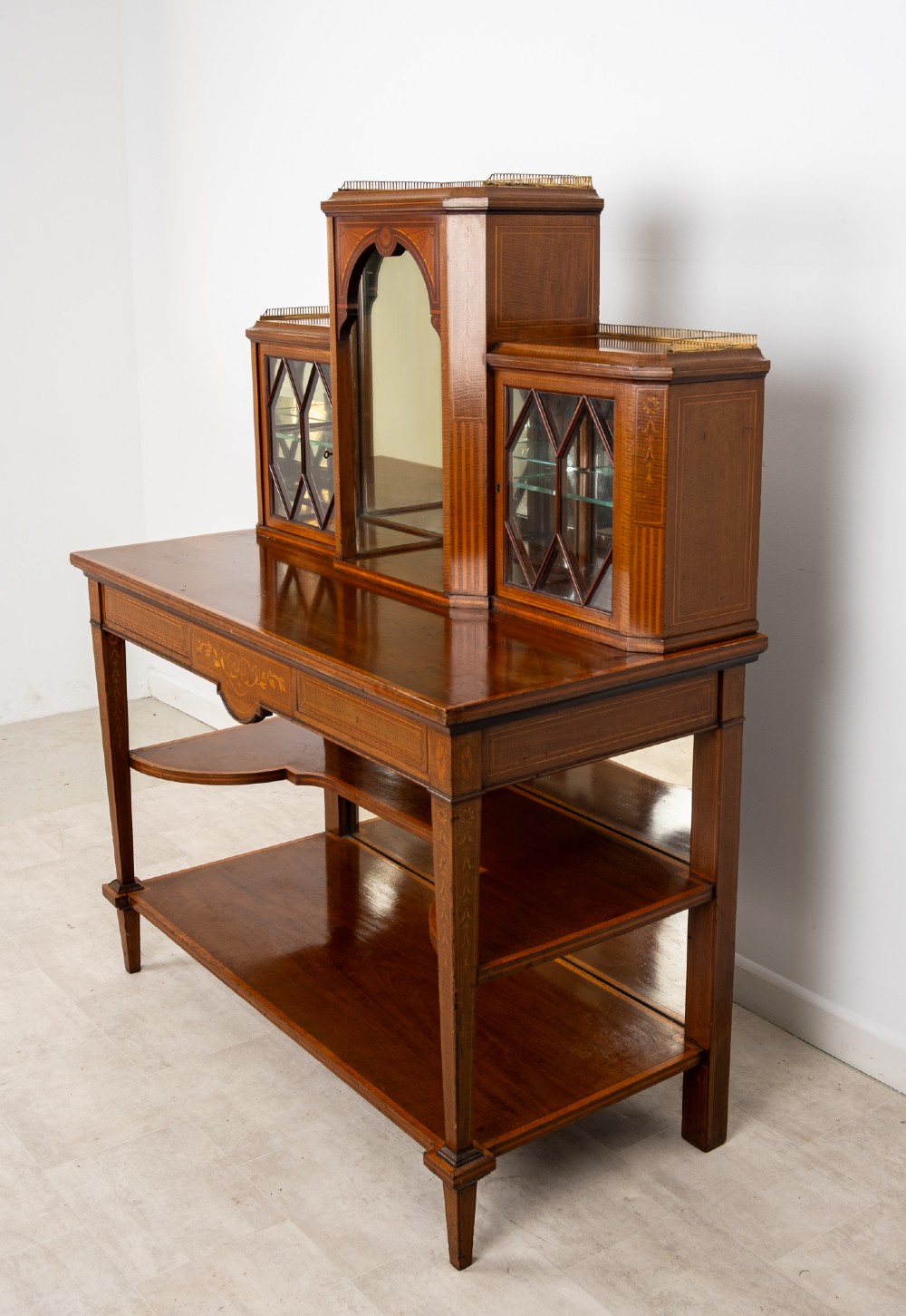 An Edwardian mahogany bonheur du jour writing desk featuring floral marquetry inlay, central mirrored recess, glazed side cabinets, and open lower shelves. View VIII