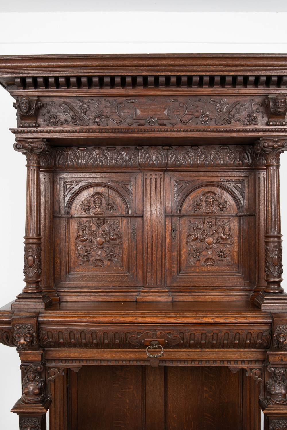 A 19th-century carved oak buffet cupboard featuring intricate relief panels, architectural columns, an upper cabinet, and an open lower tier. View VI