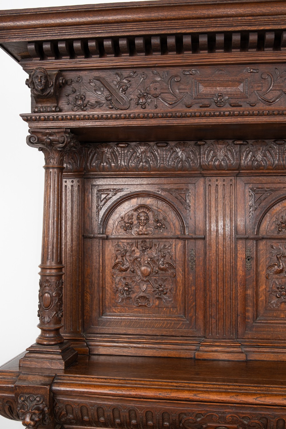 A 19th-century carved oak buffet cupboard featuring intricate relief panels, architectural columns, an upper cabinet, and an open lower tier. View VIII