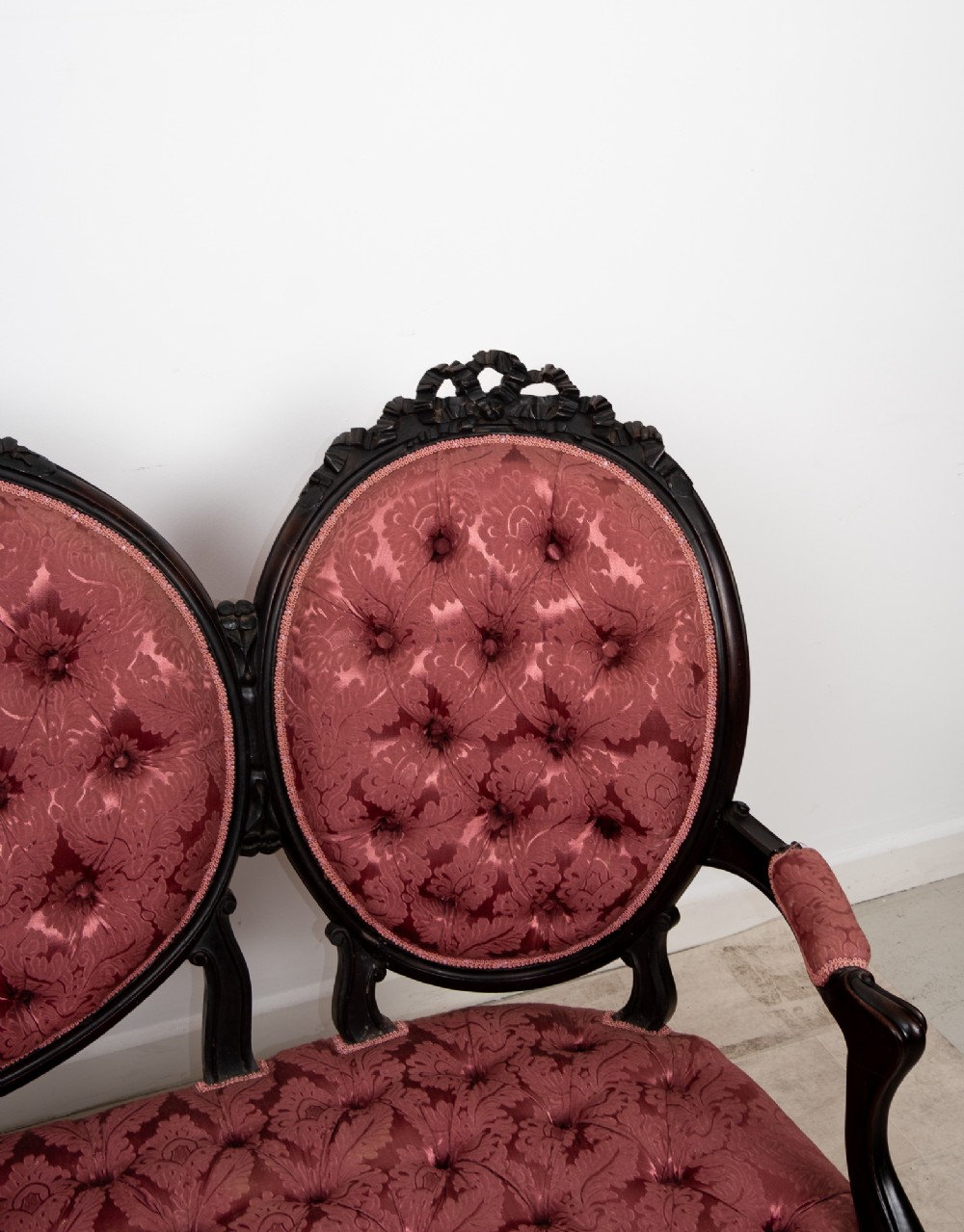 A three-piece Victorian mahogany salon suite featuring a three-back settee and two matching armchairs upholstered in rose-pink deep-buttoned fabric. View IX