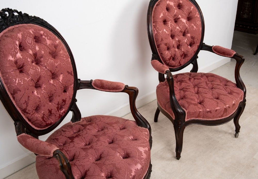 A three-piece Victorian mahogany salon suite featuring a three-back settee and two matching armchairs upholstered in rose-pink deep-buttoned fabric. View XI
