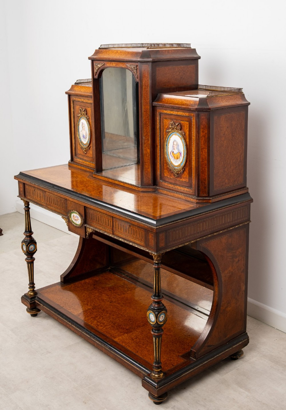 An antique French amboyna and ebonised bonheur du jour writing desk featuring inset porcelain plaques, gilt metal mounts, a central mirrored superstructure, and lower tier shelving. View III