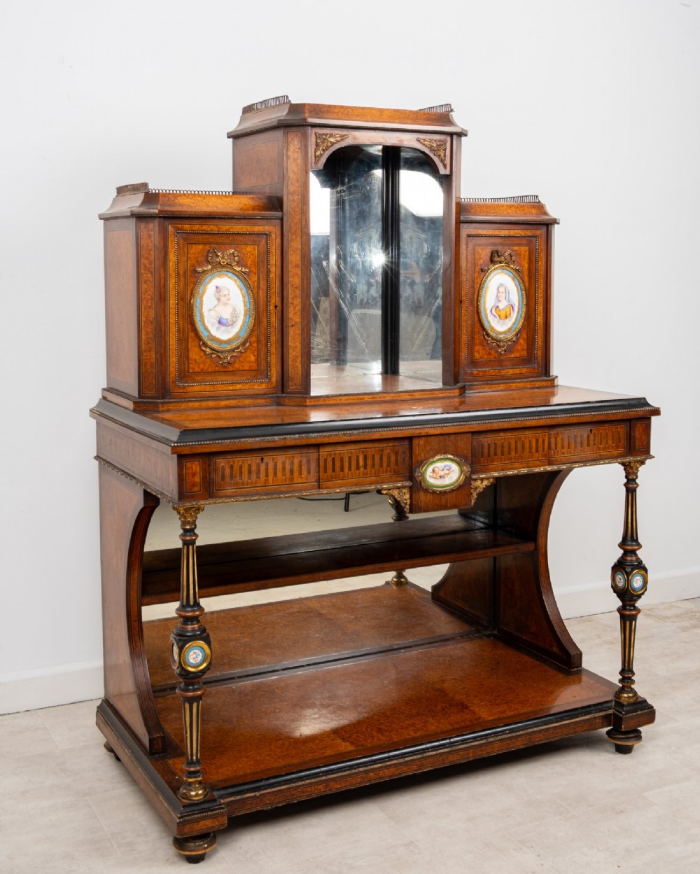 An antique French amboyna and ebonised bonheur du jour writing desk featuring inset porcelain plaques, gilt metal mounts, a central mirrored superstructure, and lower tier shelving. View IV