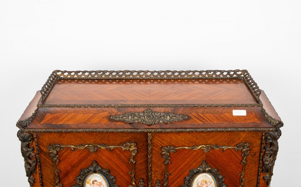 An antique French kingwood bonheur du jour writing desk featuring an upper cabinet with porcelain plaques, ornate ormolu mounts, and slender cabriole legs. View VII