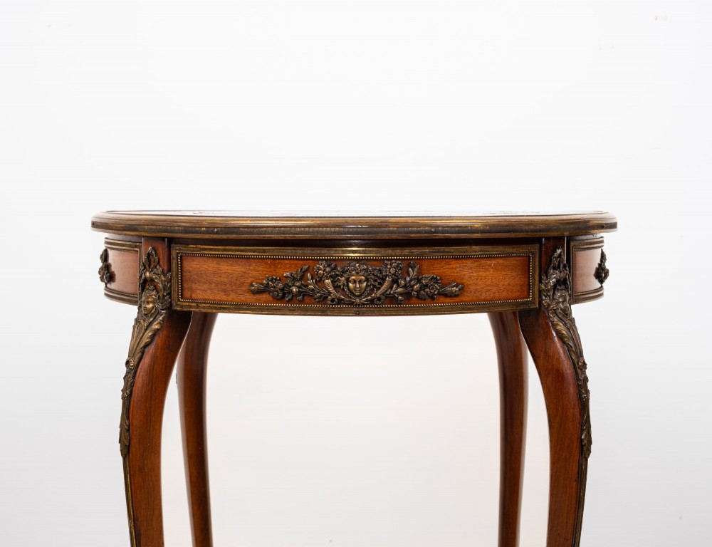 A circular French kingwood centre table featuring parquetry top inlay, gilt-bronze mounts, cabriole legs, and a central undertier basket. View V