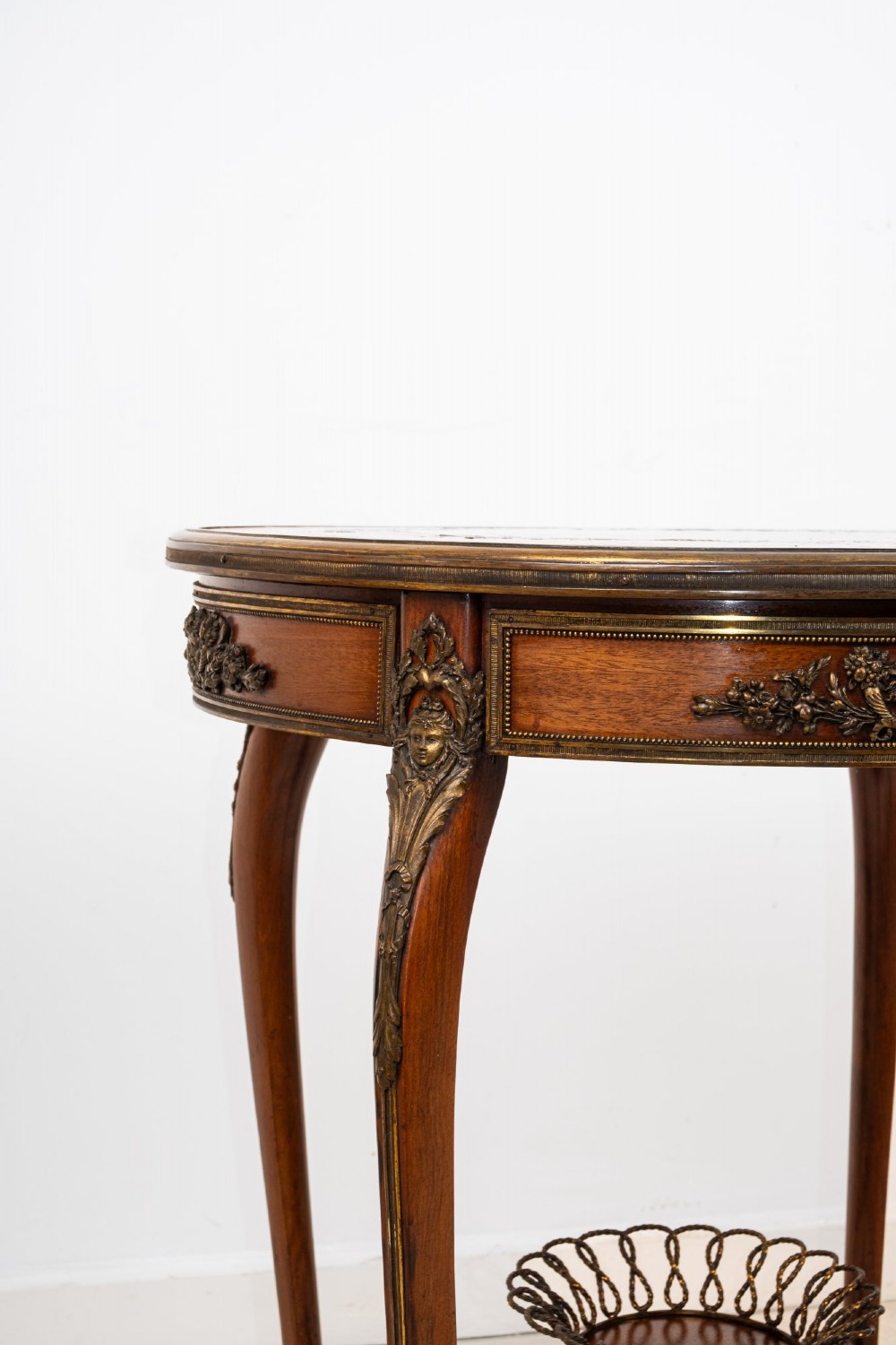 A circular French kingwood centre table featuring parquetry top inlay, gilt-bronze mounts, cabriole legs, and a central undertier basket. View VIII