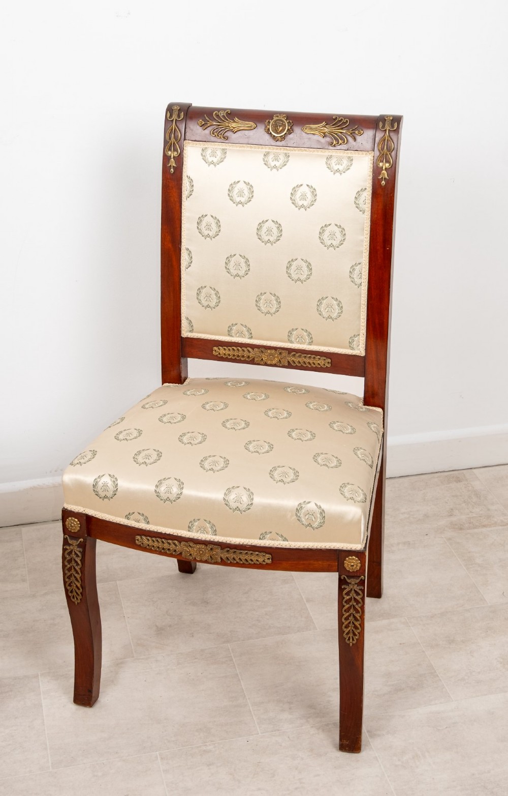 A pair of late 19th-century French Empire Revival mahogany side chairs featuring gilt-bronze ormolu mounts and cream upholstered seats and backrests. View III